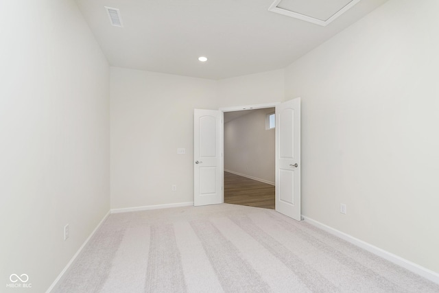 spare room with recessed lighting, light carpet, visible vents, and baseboards