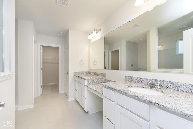 bathroom featuring visible vents, a spacious closet, vanity, and walk in shower