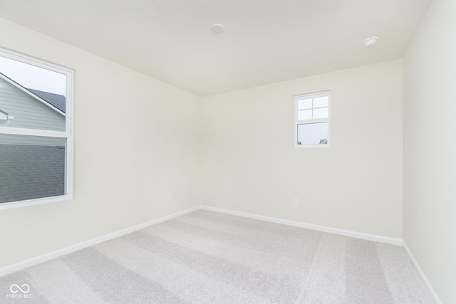 empty room featuring carpet and baseboards