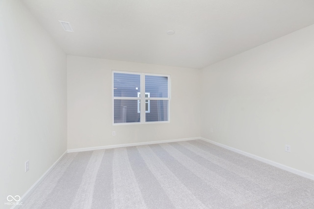 spare room with baseboards and carpet flooring