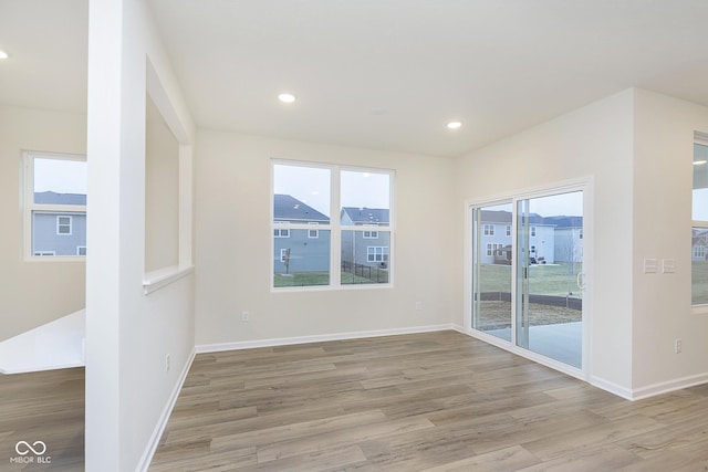 spare room with baseboards, light wood-type flooring, and recessed lighting