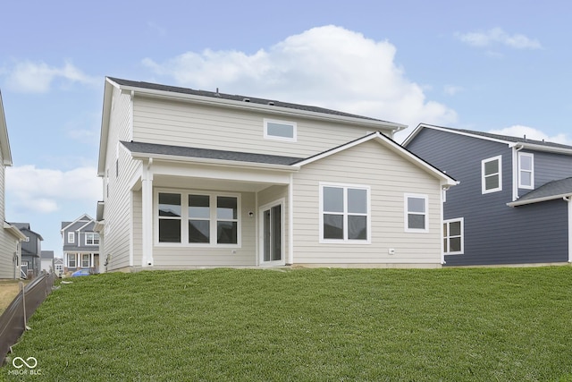 rear view of property featuring a yard and fence