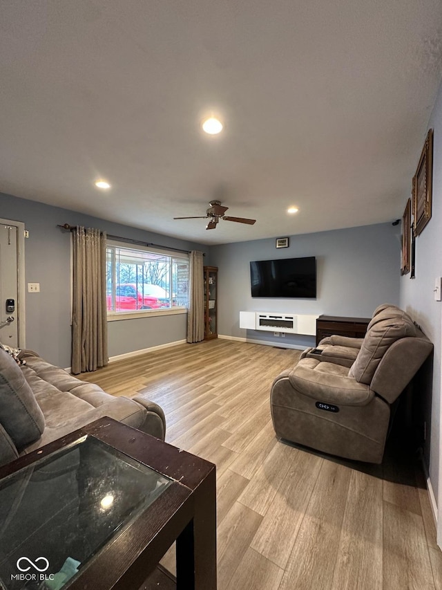 living room featuring ceiling fan and light hardwood / wood-style flooring