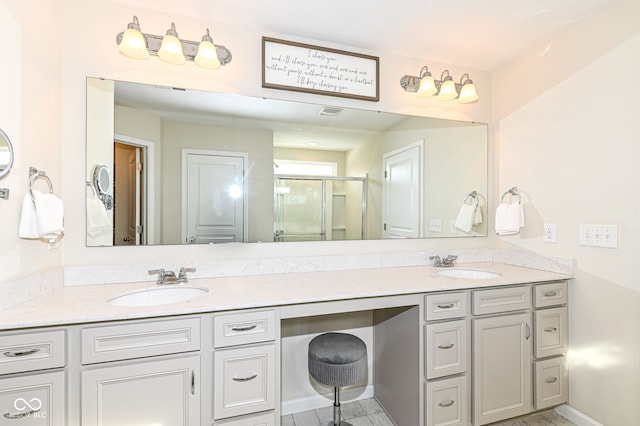 full bathroom featuring double vanity, a shower stall, and a sink