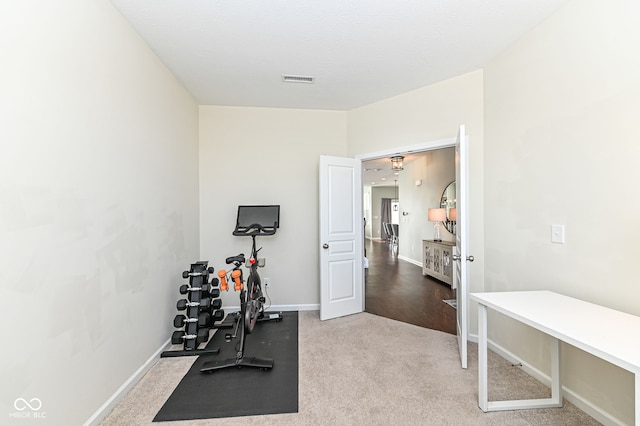 workout area featuring carpet floors, visible vents, and baseboards