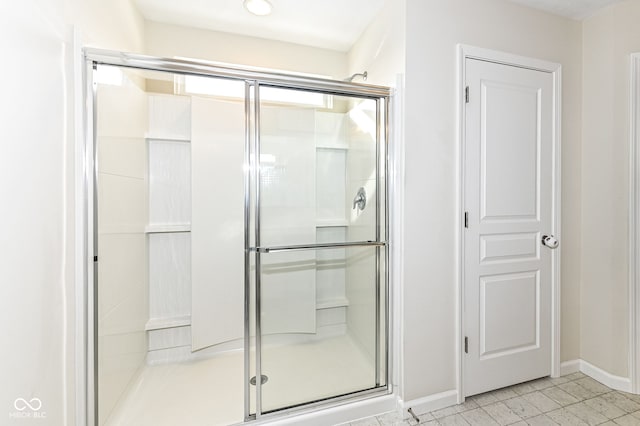 full bathroom with a stall shower and baseboards