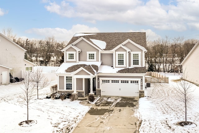 traditional-style house featuring a garage, stone siding, and driveway