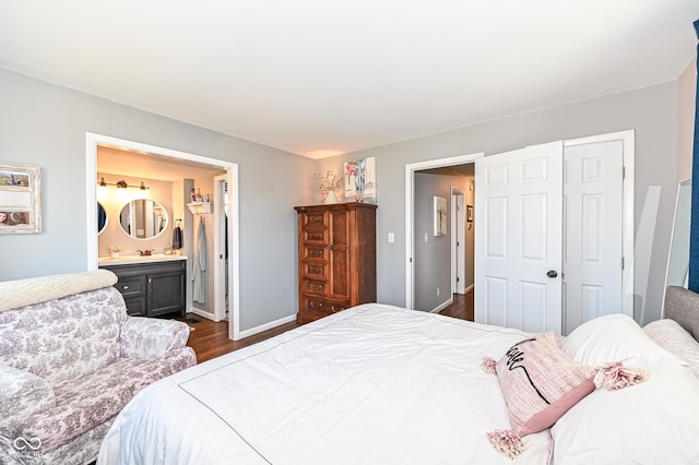 bedroom featuring connected bathroom, a closet, dark wood finished floors, and baseboards