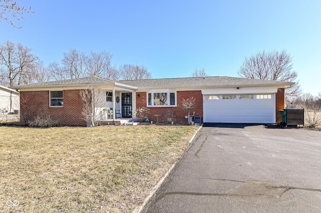 ranch-style home with a garage, driveway, a front lawn, and brick siding