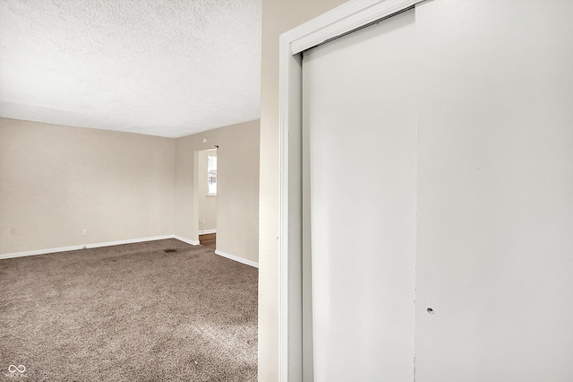 spare room featuring carpet floors and a textured ceiling