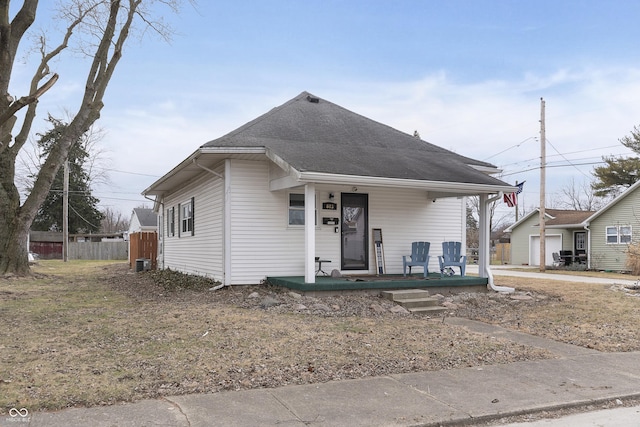 bungalow-style home with a garage, central AC, and covered porch