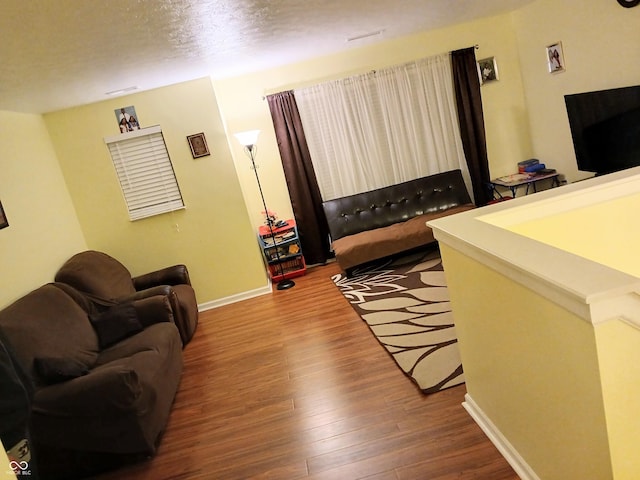 living room with hardwood / wood-style floors and a textured ceiling