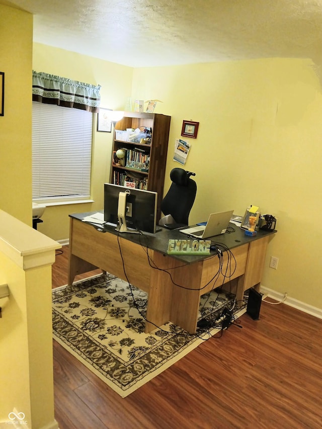 office area with dark hardwood / wood-style floors and a textured ceiling