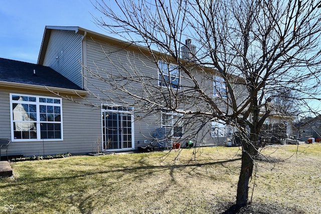 rear view of property featuring a yard