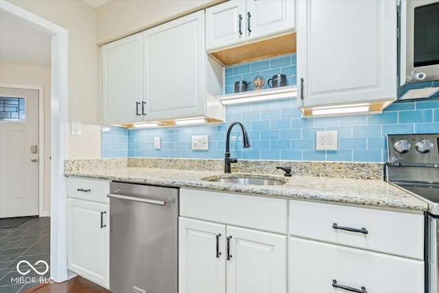 kitchen featuring white cabinetry, sink, stainless steel appliances, and light stone countertops