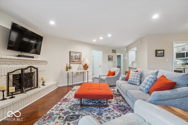 living room with dark wood-type flooring and a fireplace