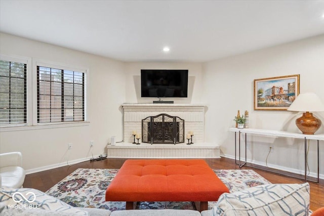 living room featuring a brick fireplace and hardwood / wood-style floors