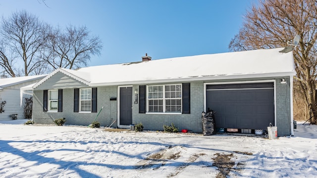 single story home featuring an attached garage, a chimney, and brick siding