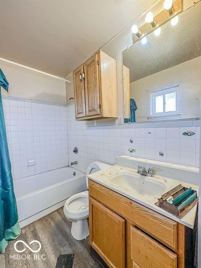 full bathroom featuring wood-type flooring, tile walls, shower / bath combination with curtain, vanity, and toilet