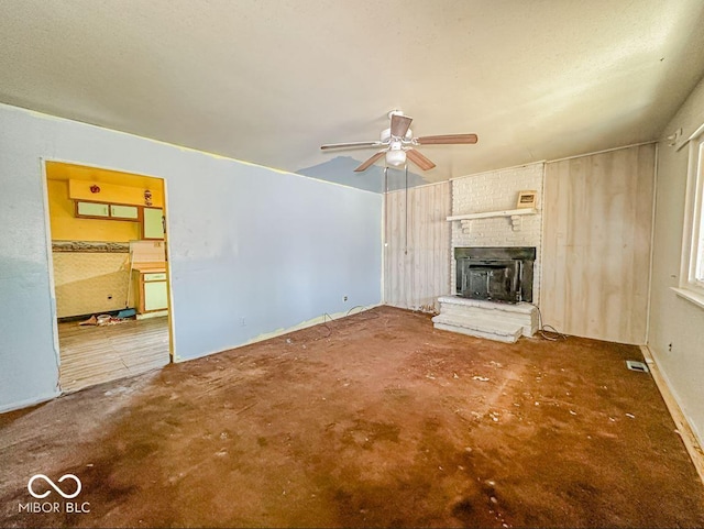 unfurnished living room featuring ceiling fan and a fireplace