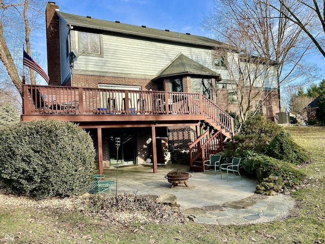 back of house with a fire pit, a patio, and a deck