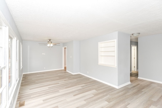 unfurnished room featuring ceiling fan, a textured ceiling, and light hardwood / wood-style flooring