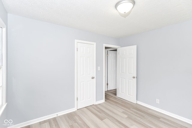 unfurnished bedroom featuring a textured ceiling and light wood-type flooring