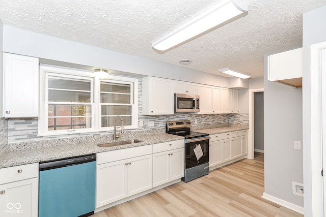 kitchen featuring white cabinetry, appliances with stainless steel finishes, and sink