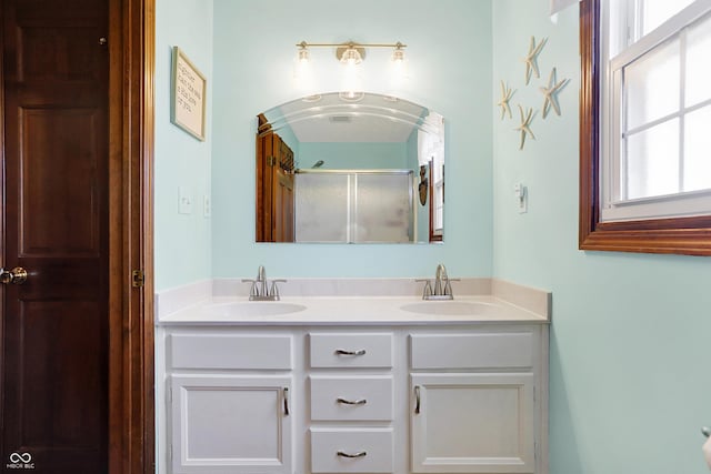 bathroom with vanity and a shower with shower door