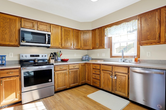 kitchen with sink, light hardwood / wood-style floors, and appliances with stainless steel finishes