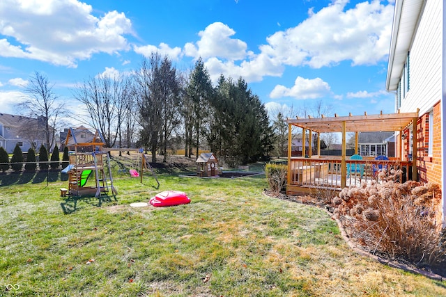 view of yard with a wooden deck, a pergola, and a playground