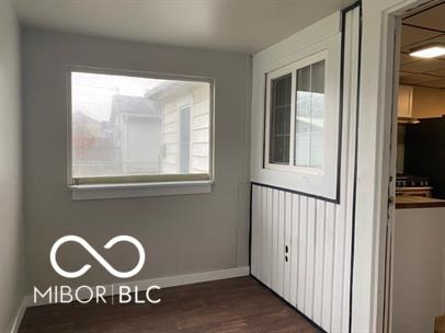 unfurnished room with dark wood-type flooring