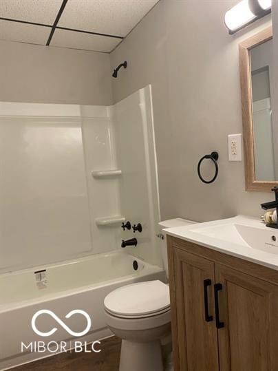 full bathroom with vanity, a paneled ceiling, toilet, and washtub / shower combination