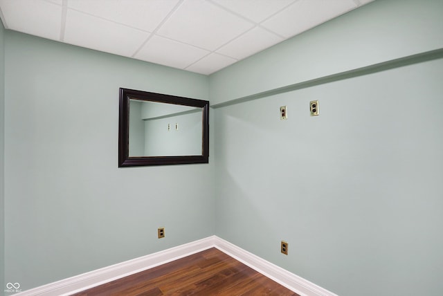 empty room with a paneled ceiling and hardwood / wood-style floors