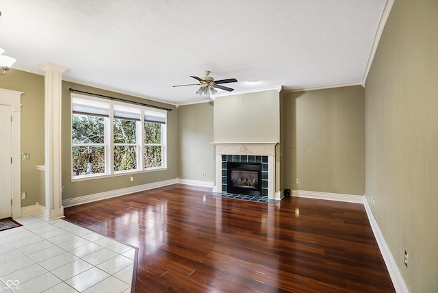 unfurnished living room featuring crown molding, ceiling fan, a fireplace, and light hardwood / wood-style flooring