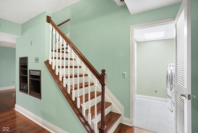 stairway with hardwood / wood-style floors and washer and clothes dryer