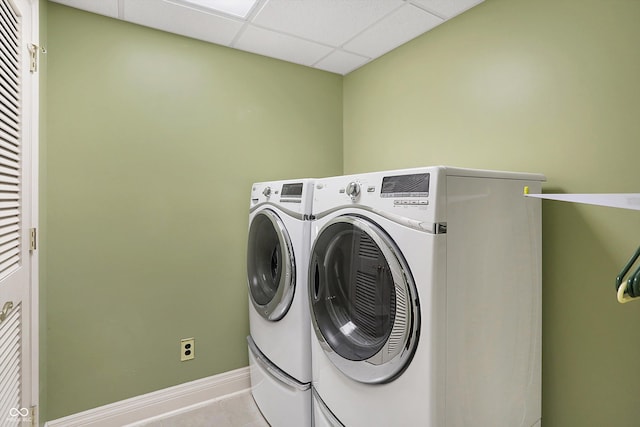 clothes washing area featuring light tile patterned floors and washer and clothes dryer