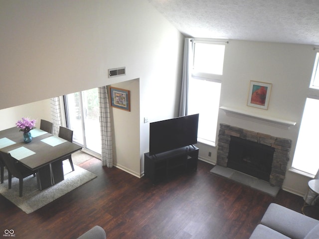 7459 Quincy Ct, Indianapolis, IN 46254 - living room featuring healthy amount of natural light, wood finished floors, a fireplace, and a textured ceiling