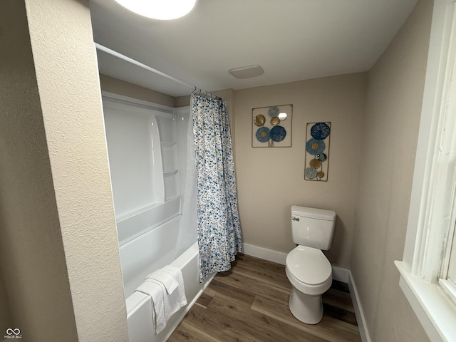 bathroom featuring hardwood / wood-style flooring, toilet, and shower / bath combo with shower curtain