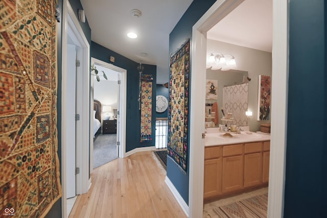 hallway featuring sink and light hardwood / wood-style floors