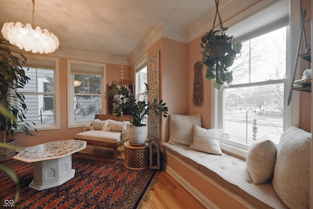 living area featuring a notable chandelier, hardwood / wood-style flooring, and ornamental molding