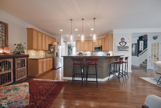 kitchen featuring crown molding, a breakfast bar, stainless steel appliances, dark hardwood / wood-style floors, and light brown cabinets