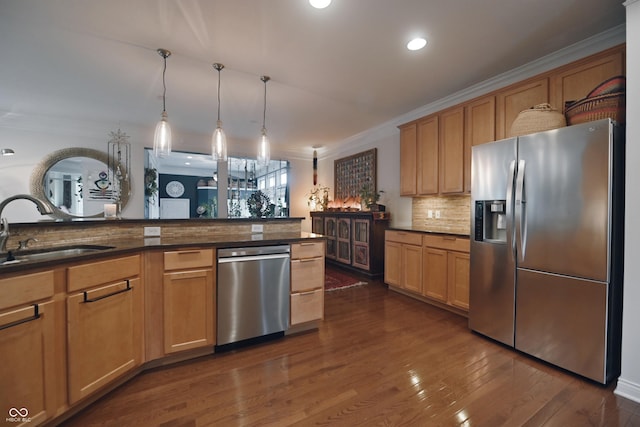 kitchen with pendant lighting, appliances with stainless steel finishes, crown molding, and sink