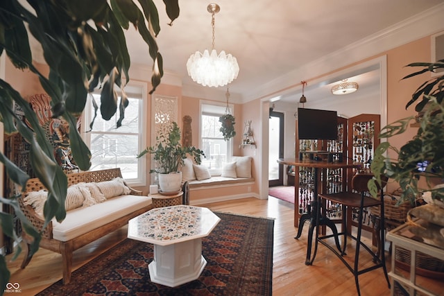 living room featuring an inviting chandelier, crown molding, and hardwood / wood-style floors