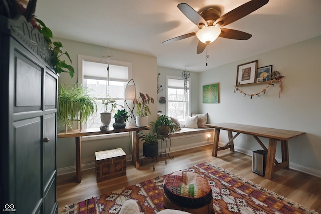 living area featuring wood-type flooring and ceiling fan