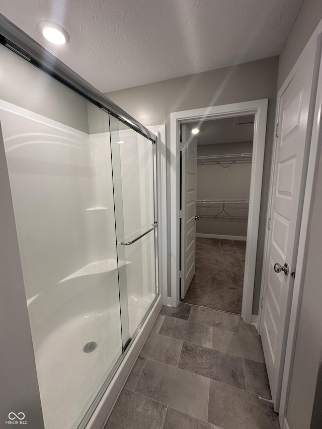 bathroom featuring an enclosed shower and a textured ceiling