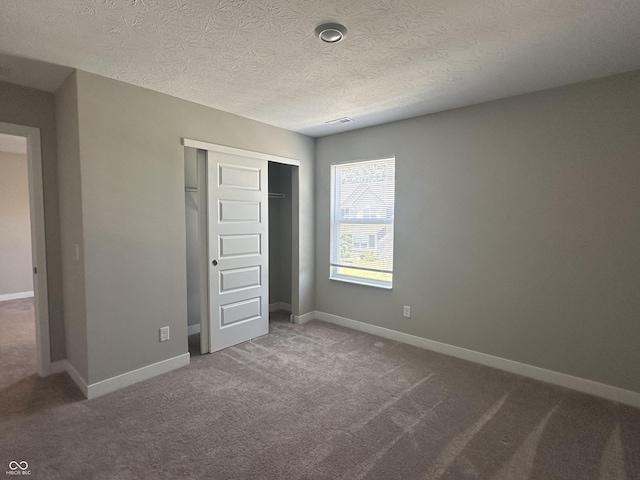 unfurnished bedroom with carpet floors, a closet, and a textured ceiling