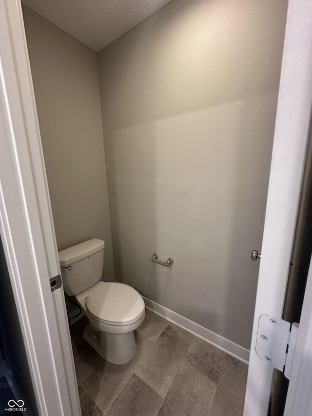 bathroom with a textured ceiling and toilet