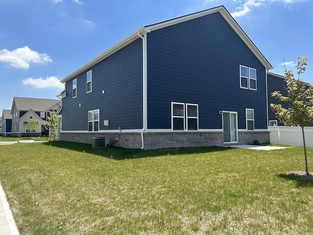 view of side of home featuring a lawn and central air condition unit