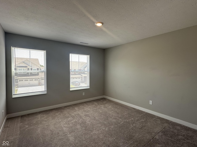 unfurnished room featuring carpet and a textured ceiling